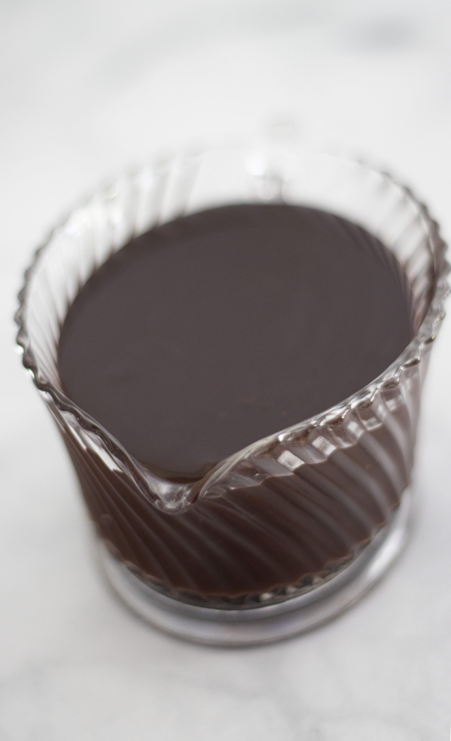 A glass jar filled with rich, easy chocolate sauce, ready for drizzling over desserts.